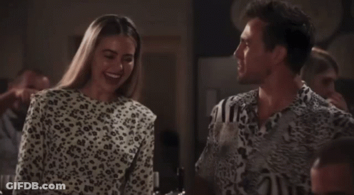 A Woman In A Leopard Print Top Smiles Next To A Man GIF