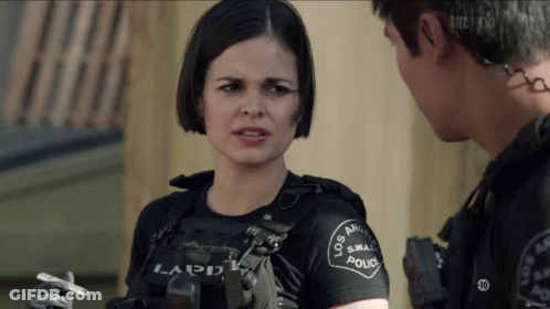A Woman In A Los Angeles Police Uniform Holds A Cigarette In Her Hand GIF