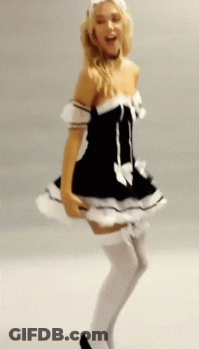 A Woman In A Maid Costume Is Dancing In Front Of A White Wall GIF