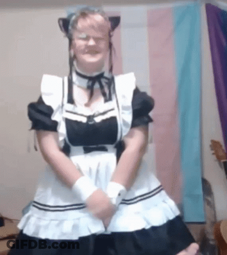 A Woman In A Maid Costume Is Standing In Front Of A Flag . GIF