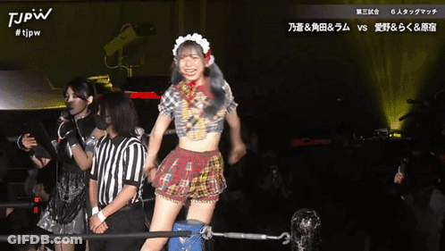 A Woman In A Maid Outfit Is Dancing In Front Of A Referee And A Sign That Says Tjpw On It GIF