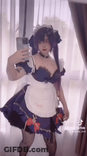 A Woman In A Maid Outfit Is Taking A Selfie GIF