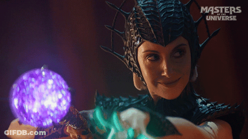 A Woman In A Masters Of The Universe Costume Holding A Purple Ball GIF