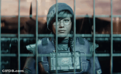A Woman In A Military Uniform Is Behind Bars And Has A Badge On Her Chest That Says ' Ec ' GIF
