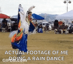 A Woman In A Native American Dress Is Dancing In A Field With The Caption " Actual Footage Of Me Doing A Rain Dance " GIF