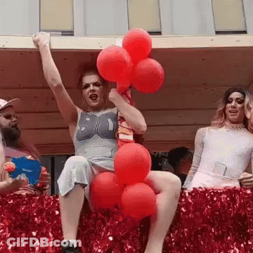 A Woman In A Number 90 Shirt Is Holding Red Balloons In Her Hand GIF