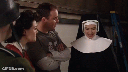 A Woman In A Nun Costume Talks To A Man Wearing A Shirt That Says 32 GIF