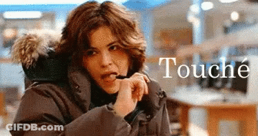 A Woman In A Parka With A Fur Hood Is Talking On A Cell Phone GIF