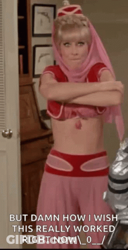 A Woman In A Pink And Red Costume Is Standing In A Room With Her Arms Crossed And A Quote . GIF
