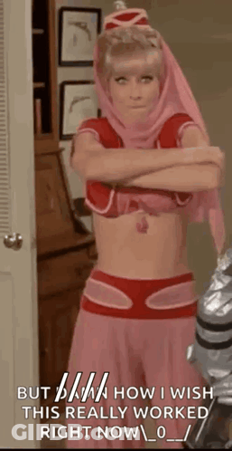A Woman In A Pink And Red Costume With Her Arms Crossed Is Standing In A Room With A Door . GIF