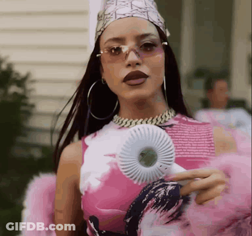 A Woman In A Pink And White Dress Is Holding A Fan GIF