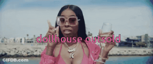 A Woman In A Pink Bikini Is Holding A Glass And The Words Dollhouse Outsold GIF