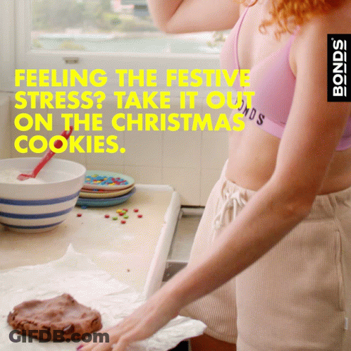 A Woman In A Pink Bra And Shorts Is Baking Cookies With The Words Feeling The Festive Stress Take It Out On The Christma GIF
