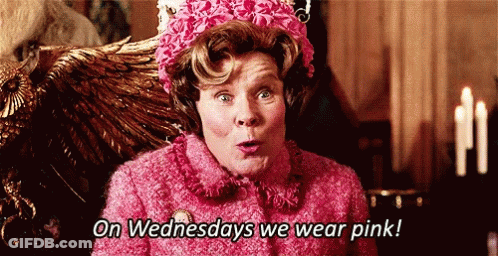 A Woman In A Pink Coat And Hat Says On Wednesdays We Wear Pink . GIF