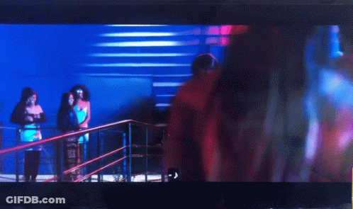 A Woman In A Pink Crop Top Is Dancing In Front Of A Crowd GIF
