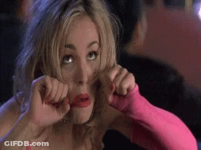 A Woman In A Pink Dress And Pink Gloves Is Making A Face . GIF