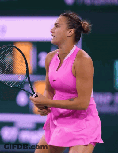 A Woman In A Pink Dress Holding A Tennis Racquet GIF