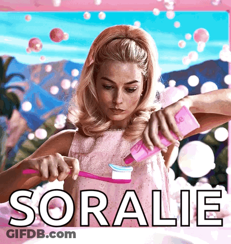 A Woman In A Pink Dress Is Brushing Her Teeth And The Name Soralie Is On The Bottom Right GIF