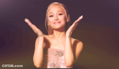 A Woman In A Pink Dress Is Clapping Her Hands In The Air GIF