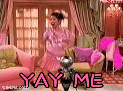 A Woman In A Pink Dress Is Dancing In A Living Room With The Words Yay Me Written On The Bottom GIF