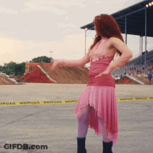 A Woman In A Pink Dress Is Dancing In Front Of A Yellow Caution Tape That Says " Hoituad " GIF