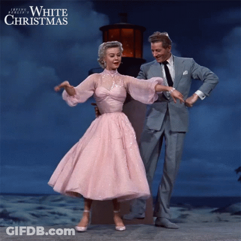 A Woman In A Pink Dress Is Dancing With A Man In A Suit In A White Christmas Poster GIF