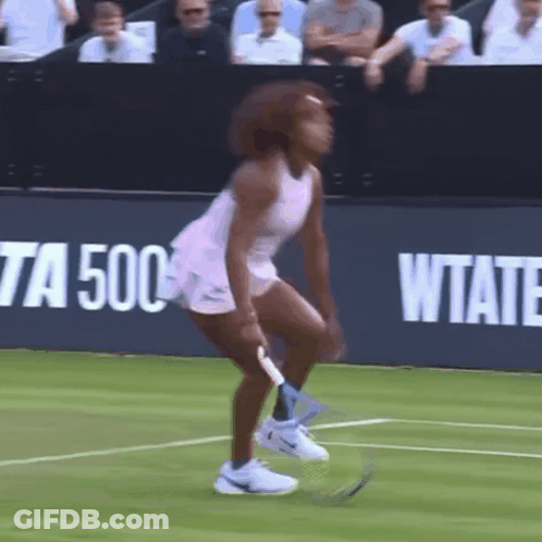 A Woman In A Pink Dress Is Holding A Tennis Racquet On A Tennis Court In Front Of A Sign That Says Wtate GIF