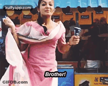A Woman In A Pink Dress Is Holding An Ice Cream Cone And Dancing In Front Of An Ice Cream Stand . GIF
