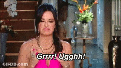 A Woman In A Pink Dress Is Holding Her Hair In A Braid And Saying Grrr ! Ugghh ! GIF