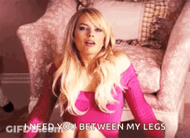 A Woman In A Pink Dress Is Sitting In A Chair . GIF