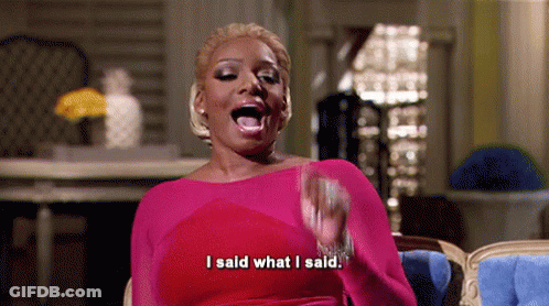 A Woman In A Pink Dress Is Sitting In A Chair With Her Mouth Open And Saying `` I Said What I Said '' . GIF