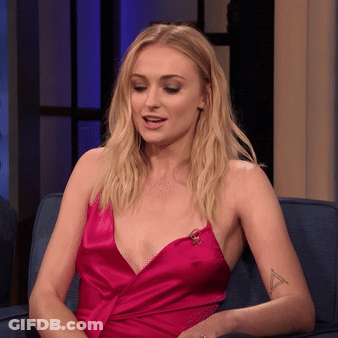A Woman In A Pink Dress Is Sitting On A Blue Couch GIF