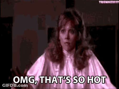 A Woman In A Pink Dress Is Standing In A Dark Room And Says `` Omg , That 'S So Hot '' . GIF