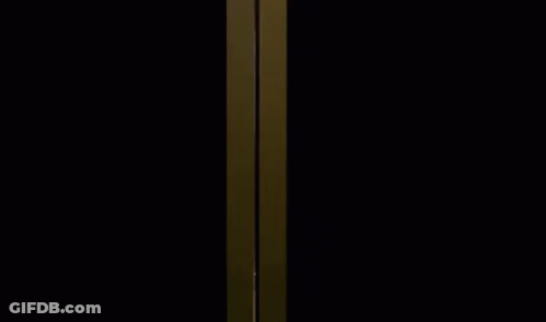 A Woman In A Pink Dress Is Standing In A Dressing Room . GIF