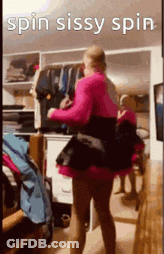 A Woman In A Pink Dress Is Standing In Front Of A Closet . GIF