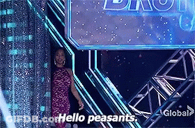 A Woman In A Pink Dress Is Standing In Front Of A Sign That Says Hello Peasants GIF
