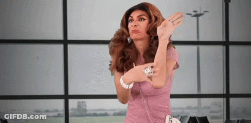 A Woman In A Pink Dress Is Standing In Front Of A Window With Her Hands In The Air . GIF