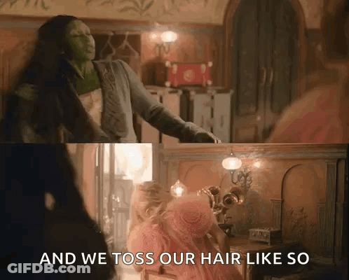 A Woman In A Pink Dress Is Standing Next To A Woman In A Green Dress In A Room . GIF
