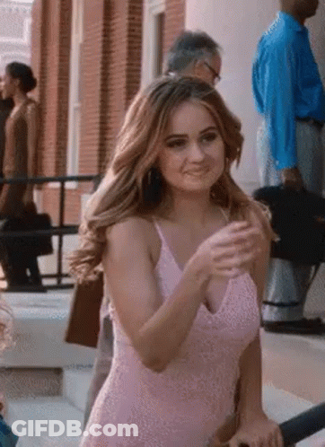 A Woman In A Pink Dress Is Standing On The Steps Of A Building . GIF