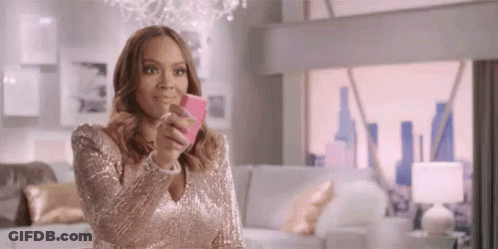 A Woman In A Pink Dress Is Taking A Selfie With Her Cell Phone . GIF