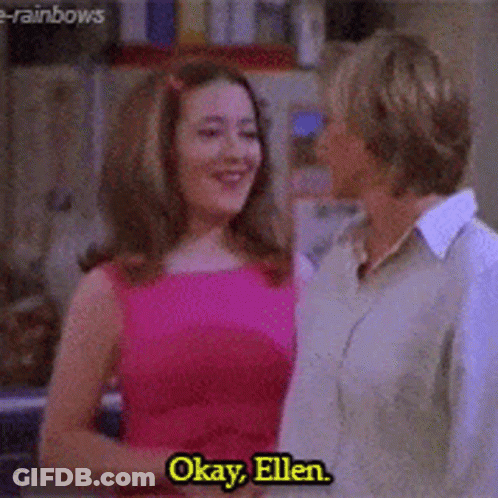 A Woman In A Pink Dress Is Talking To A Woman In A Tan Shirt With The Words Okay Ellen On The Bottom GIF