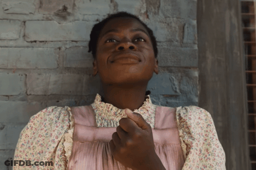 A Woman In A Pink Dress Looks Up At The Sky GIF