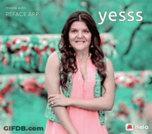 A Woman In A Pink Dress Stands In Front Of A Green Background With The Word Yesss Written Above Her GIF