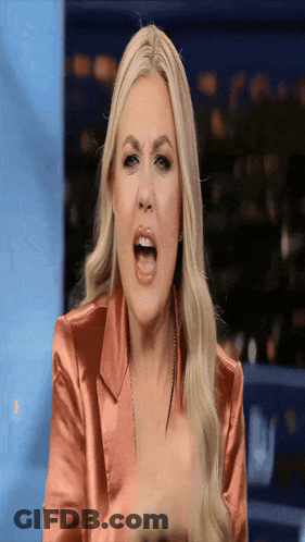 A Woman In A Pink Jacket Is Making A Funny Face With Her Mouth Open GIF