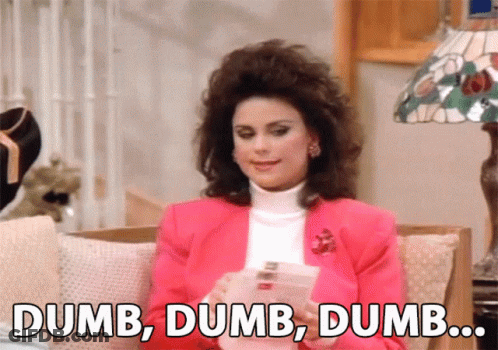 A Woman In A Pink Jacket Is Sitting On A Couch And Says Dumb Dumb Dumb .. GIF