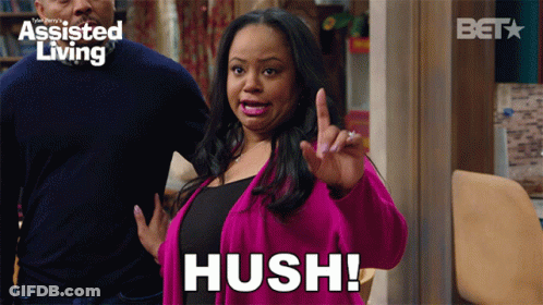 A Woman In A Pink Jacket Says Hush In Front Of A Bet Logo GIF