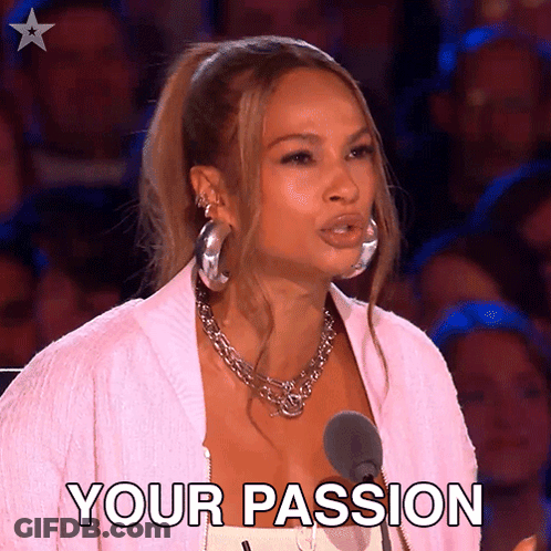 A Woman In A Pink Jacket Stands In Front Of A Microphone And Says " Your Passion " . GIF