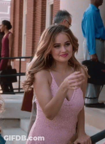 A Woman In A Pink Lace Dress Is Standing On A Set Of Stairs GIF