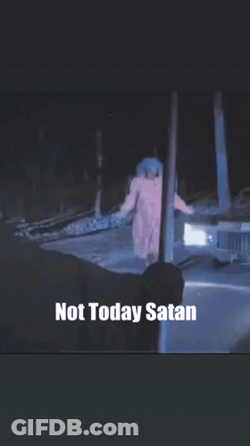 A Woman In A Pink Robe Is Holding A Gun In Front Of A Car With The Words " Not Today Satan " Below Her GIF