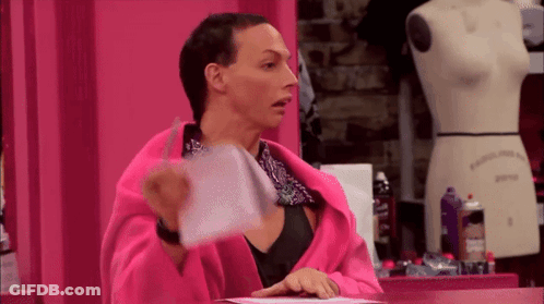 A Woman In A Pink Robe Is Holding A Piece Of Paper In Front Of A Mannequin GIF